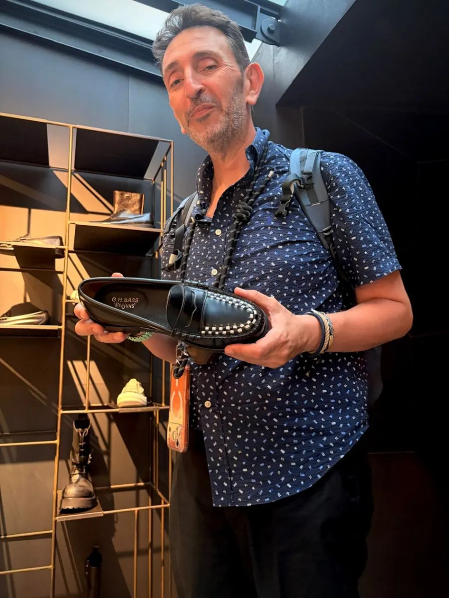 Holding a studded loafer at a stand during MICAM Milano
